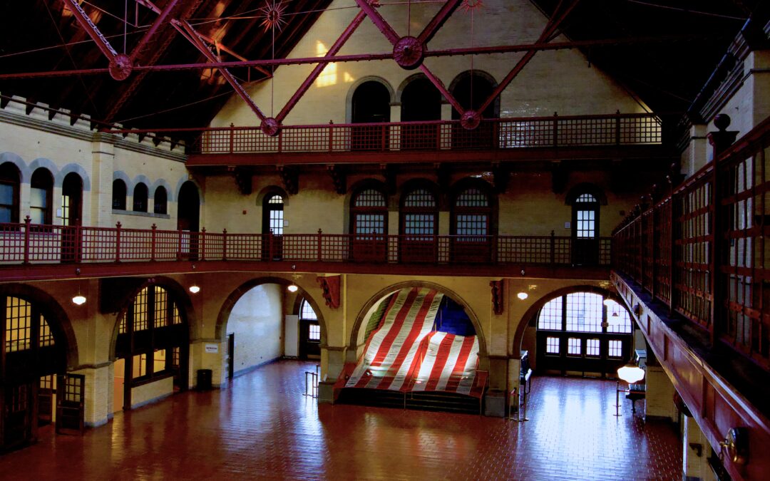 a textile flag installation is displayed on a staircase in the center of a large empty hall