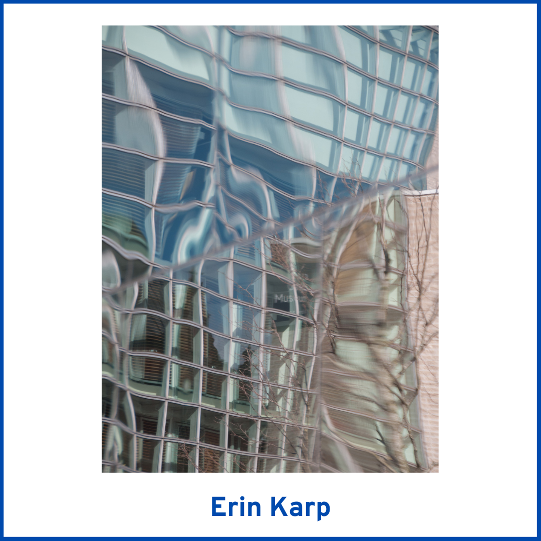 photograph of a glass high-rise with warped reflections of the sky and surrounding buildings